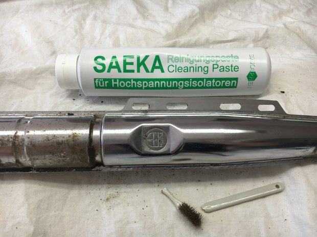 A part of a chrome plated motor cycle exhaust cleaned with SAEKA-Cleaning Paste 80.750 showing the before and after