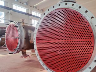 Due scambiatori di calore, uno a passaggio singolo e uno a doppio passaggio, con le piastre tubiere rivestite con Säkatonit K80LS, prodotto polimerizzante a freddo per applicazioni gravose Due scambiatori di calore, uno a passaggio singolo e uno a doppio passaggio, con le piastre tubiere rivestite con Säkatonit K80LS, prodotto polimerizzante a freddo per applicazioni gravose