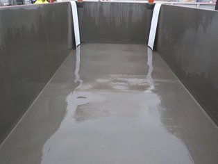 Bac de rétention d'urgence mis en place, avec des feuilles de PTFE blanc pour protéger ses bords lors de la mise en place d'un conteneur citerne ISO présentant une fuite